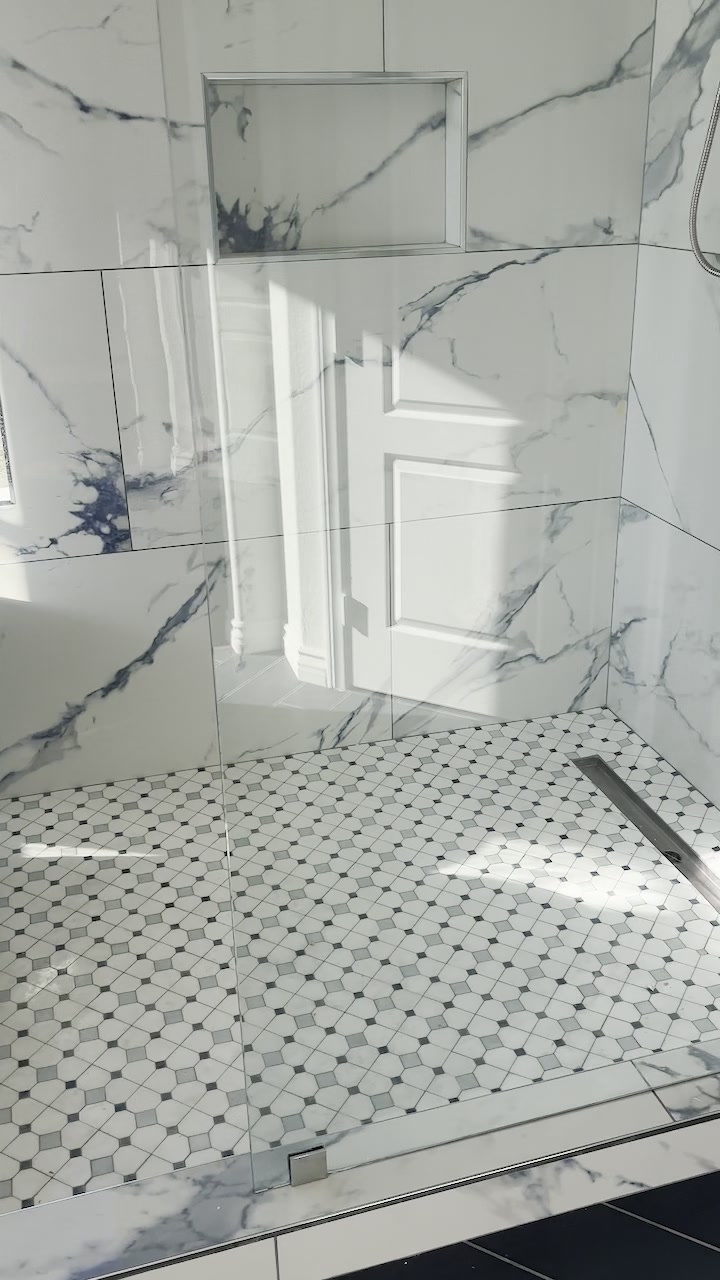 Custom marble-look tile shower with niche and mosaic pan